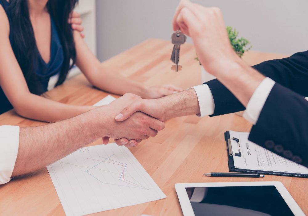 Realtor shaking hands new house owner